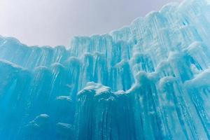 traslucido blu ghiaccioli nel un' congelato ghiaccio parete. foto