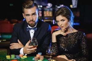 bellissimo e ricco coppia giocando roulette nel il casinò foto