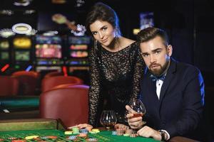 bellissimo e ricco coppia giocando roulette nel il casinò foto