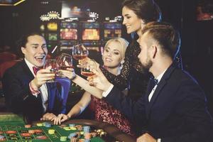 persone festeggiare loro vincere dopo riuscito gioco nel il casinò foto