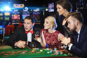 giovane e ricco persone giocando roulette nel il casinò foto