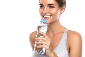 contento sorridente donna con un' bottiglia di acqua foto