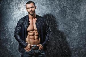 bello giovane bodybuilder mostrando il suo muscolare corpo foto