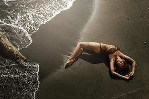 sexy donna con bellissimo corpo è dire bugie su il spiaggia foto