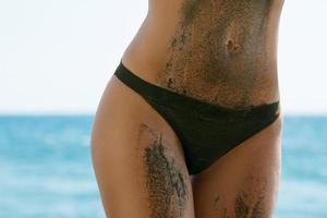 femmina corpo nel sporco o buio sabbia su il spiaggia foto