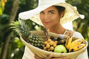 bellissimo donna indossare a tesa larga cappello nel il tropicale giardino foto