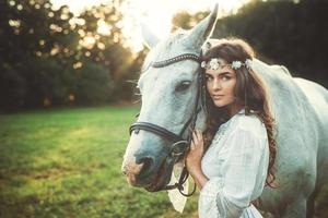 donna nel bellissimo bianca vestito e sua bellissimo cavallo foto