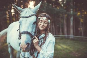 giovane donna nel bellissimo bianca vestito e sua bellissimo cavallo foto