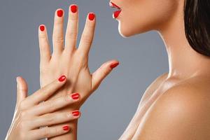 bellezza e cosmetici. femmina bocca e Chiodi con rosso manicure e rossetto. foto