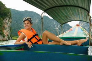 giovane donna su il coda lunga barca durante sua vacanze nel Tailandia foto