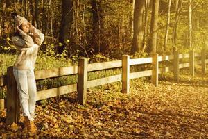 giovane e contento donna nel il parco a soleggiato autunno giorno foto