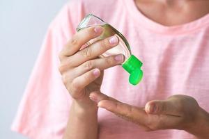 donna con un' piccolo bottiglia di mano disinfettante foto