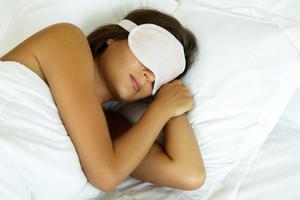 addormentato donna indossare occhio maschera nel il Camera da letto foto