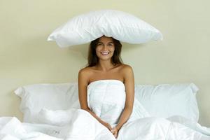 contento donna con un' cuscino su sua testa foto