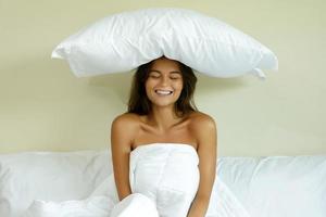 contento donna con un' cuscino su sua testa foto