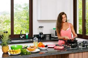 donna casalinga durante cucinando processi nel il cucina foto