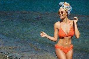 donna nel bikini e occhiali da sole il spiaggia foto