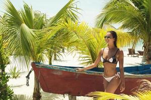 bellissimo donna su il spiaggia accanto vecchio barca foto