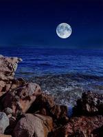 pieno Luna su rosso mare e montagne foto