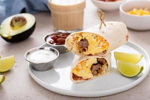 prima colazione burrito con salsiccia, uova, hashbrown e formaggio foto