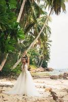 sensuale sposa indossare bellissimo nozze vestito su il tropicale isola foto