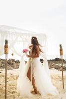 giovane sposa nel bellissimo nozze vestito su il spiaggia foto