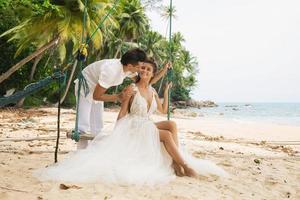 contento giovane sposato coppia festeggiare loro nozze su il spiaggia foto