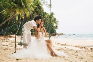 contento giovane sposato coppia festeggiare loro nozze su il spiaggia foto