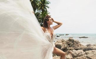 sposa indossare bellissimo nozze vestito su il tropicale spiaggia foto