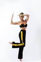 elegante donna con giallo capelli e pantaloni da ginnastica su grigio sfondo foto