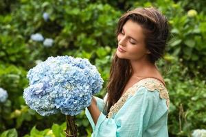 giovane e bellissimo donna fioraio raccolta ortensia fiori foto
