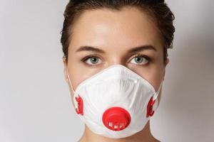 giovane donna è indossare un' viso maschera per protezione contro virus foto
