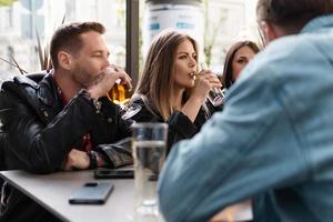 gruppo di amici siamo potabile birra e cocktail nel un' bar foto