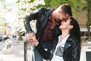 bellissimo coppia nel amore indossare pelle giacche durante un' Data su un' città strada foto