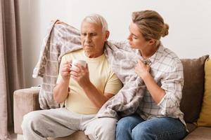 donna assunzione cura di sua anziano nonno con un' freddo sintomi foto