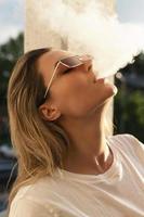donna soffiaggio Fumo su durante fumo Vape o narghilè foto