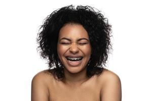 contento sorridente nero donna con un' dentale bretelle su sua denti foto