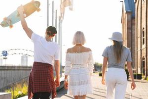 tre contento adolescenziale amici a piedi nel un' città foto