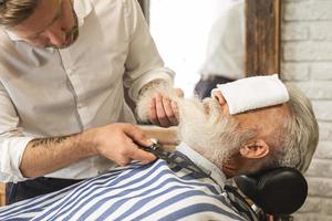 bello anziano uomo ottenere messa in piega e Rifinitura di il suo barba foto