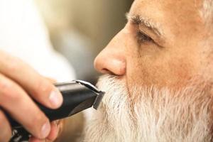 bello anziano uomo ottenere messa in piega e Rifinitura di il suo barba foto