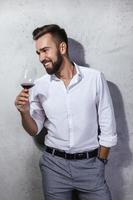 bello barbuto uomo è degustazione un' rosso vino foto