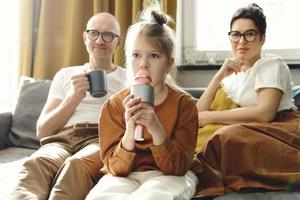 poco ragazza con un' karaoke microfono cantando per sua genitori foto