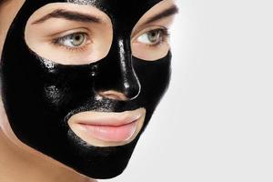 donna con in profondità detergente nero maschera su sua viso foto
