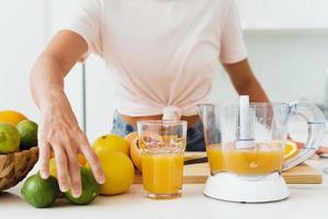 bicchiere di arancia succo e agrume spremiagrumi su il cucina tavolo foto