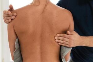 massaggiatore uomo fare indietro massaggio per il suo donna cliente foto
