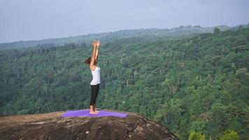 le donne asiatiche si rilassano durante le vacanze. gioca se lo yoga. sulla rupe rocciosa della montagna. natura delle foreste di montagna in thailandia. giovane donna che pratica yoga nella felicità femminile della natura. esercizio di yoga foto