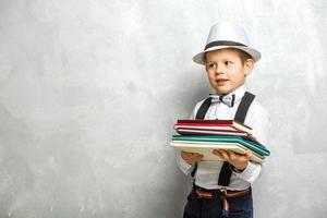 elementare scuola alunno trasporto i Quaderni al di sopra di un' grigio sfondo foto