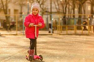 poco ragazza equitazione un' monopattino foto