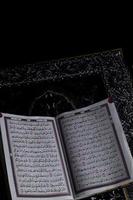 al-quran quale è sopra il preghiera tappeto con un' nero sfondo foto