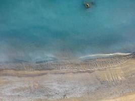 un' tropicale bianca spiaggia con blu acqua foto